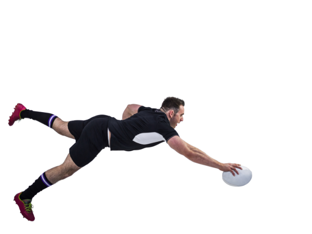 Rugby player diving to catch the ball mid-air.