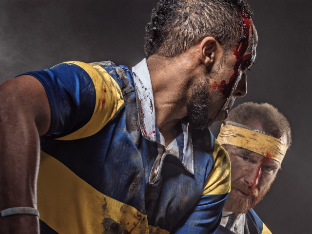 Rugby players with bloodied faces showing the intensity of the game.