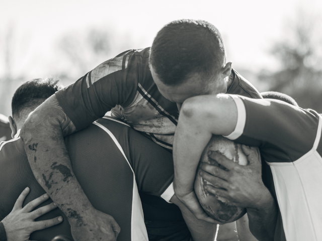 A close-up of rugby players locked in a scrum during a match.