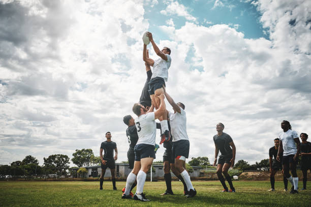 Rugby players in a lineout contest during a match, jumping to catch the ball.