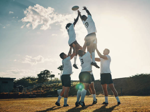 Rugby players in a lineout lifting a teammate to catch the ball.