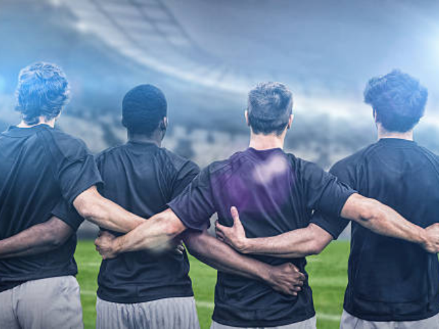 Rugby players standing with arms around each other, preparing for the game.