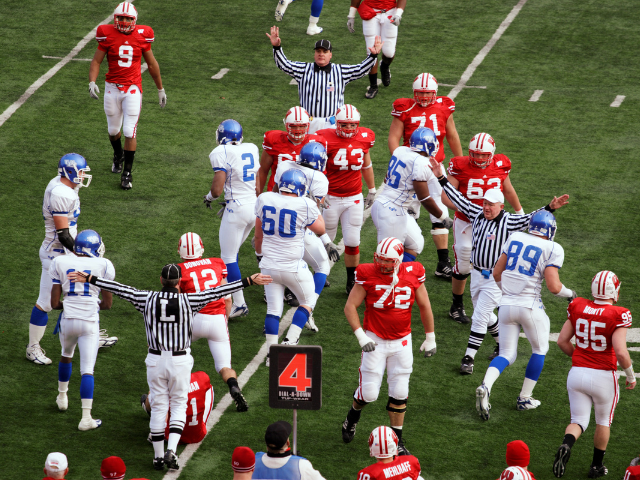 Football players and referees on the field during a game.