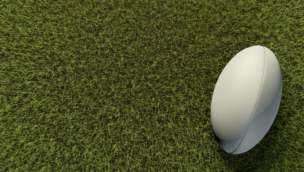 Rugby ball on a field of synthetic grass viewed from above.