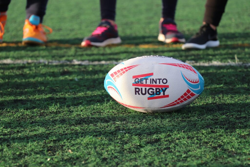 feet of rugby players behind a rugby ball