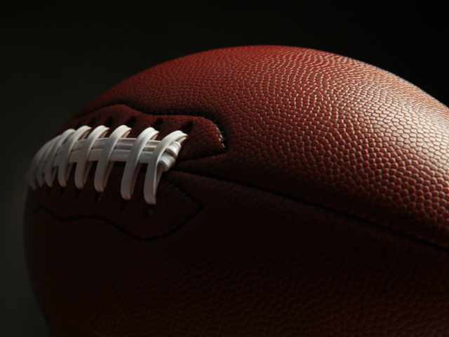 Side view of a classic football with a focus on its textured surface.