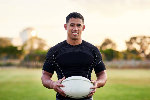 Smiling rugby player holding a ball