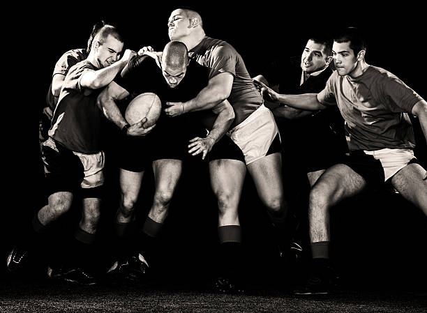 Intense rugby players battling for the ball in a black-and-white action shot.