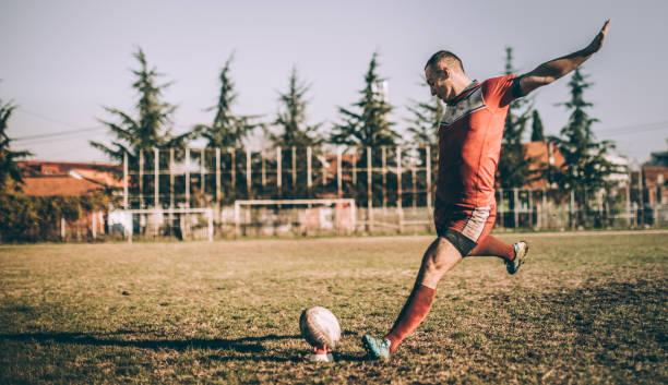 Rugby player preparing to kick the ball during practice.