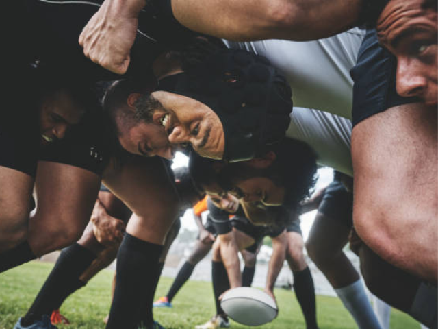 Close-up of a rugby scrum with players locked in formation and the ball visible in the center.