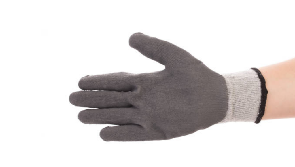 A gray knitted glove being worn on a person's hand, with a focus on the front side of the glove.