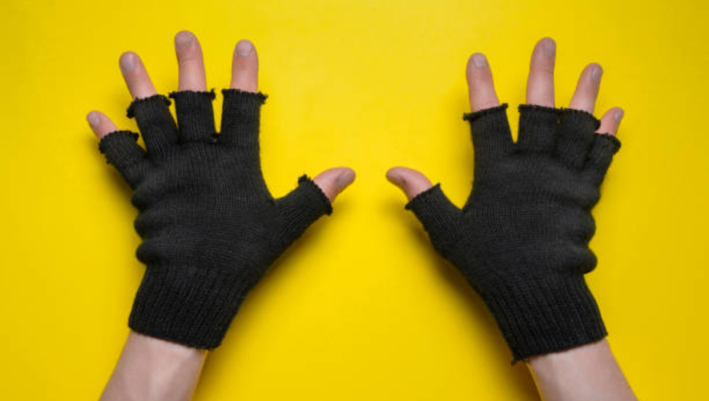 A pair of black, fingerless wool gloves with frayed ends, placed on a bright yellow background.