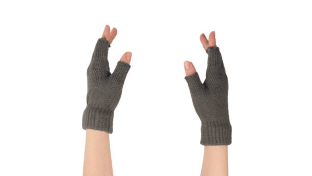 A person wearing gray knit fingerless gloves, hands raised and positioned in an upward motion.