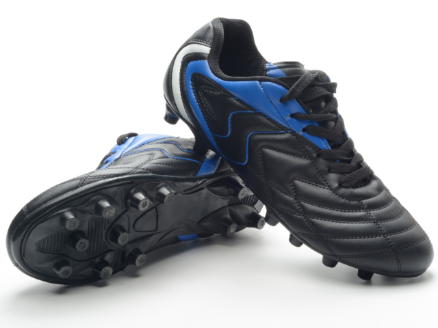 A pair of black rugby boots with blue accents, displayed with one shoe upright and the other laying down, showing the stud pattern.