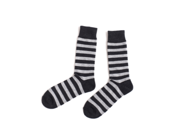 A pair of rugby socks with horizontal black and white stripes laid flat against a white background.