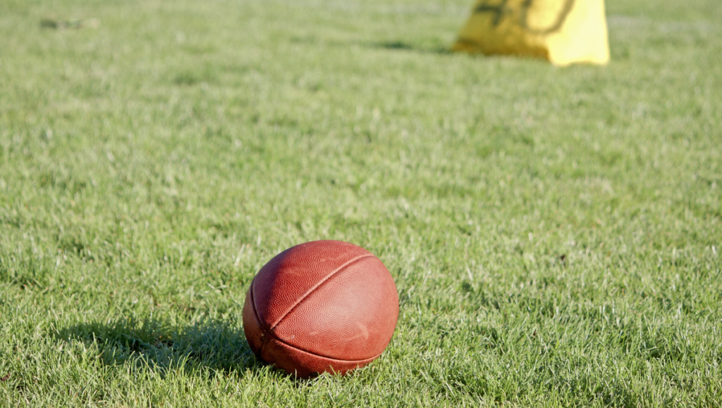 A rugby ball resting on grass during training.