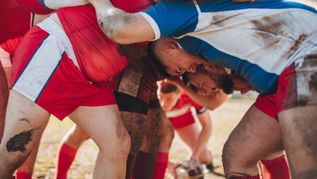 Close-up of rugby players in a scrum, showing determination and teamwork.