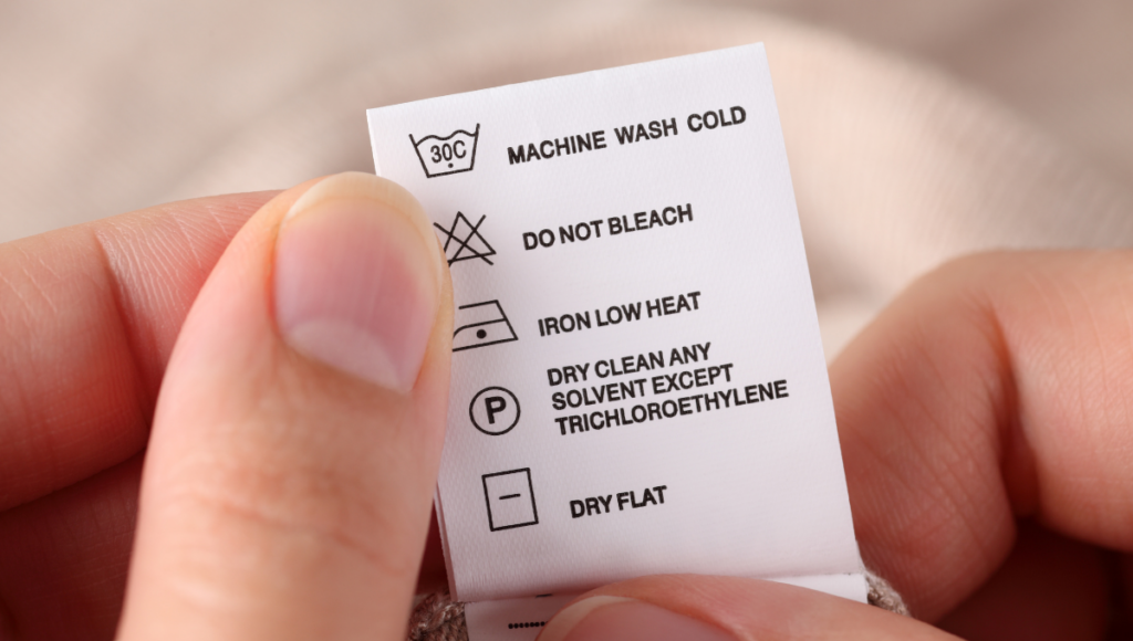 Close-up of a clothing care label showing washing and drying instructions.