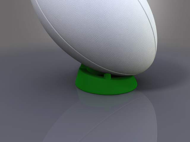 A white rugby ball placed on a green adjustable tee, ready for a kick.