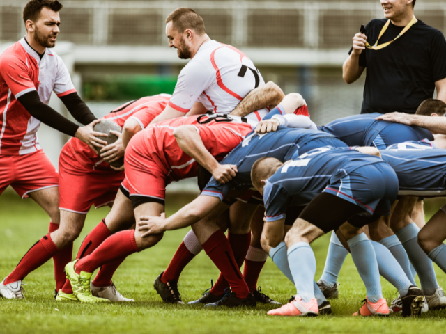 Rugby players in a scrum position, preparing for a restart.