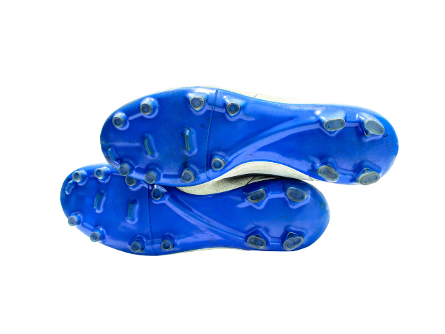 A pair of rugby boots showing the blue sole with multiple studs for better grip on the field.